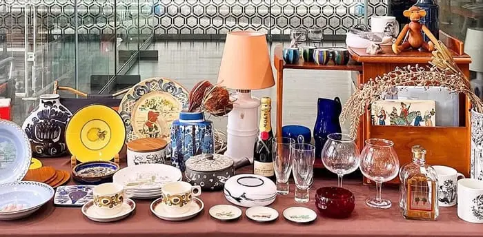 色とりどりの皿やカップ、グラスが並ぶ、アンティーク調のカフェのディスプレイテーブル