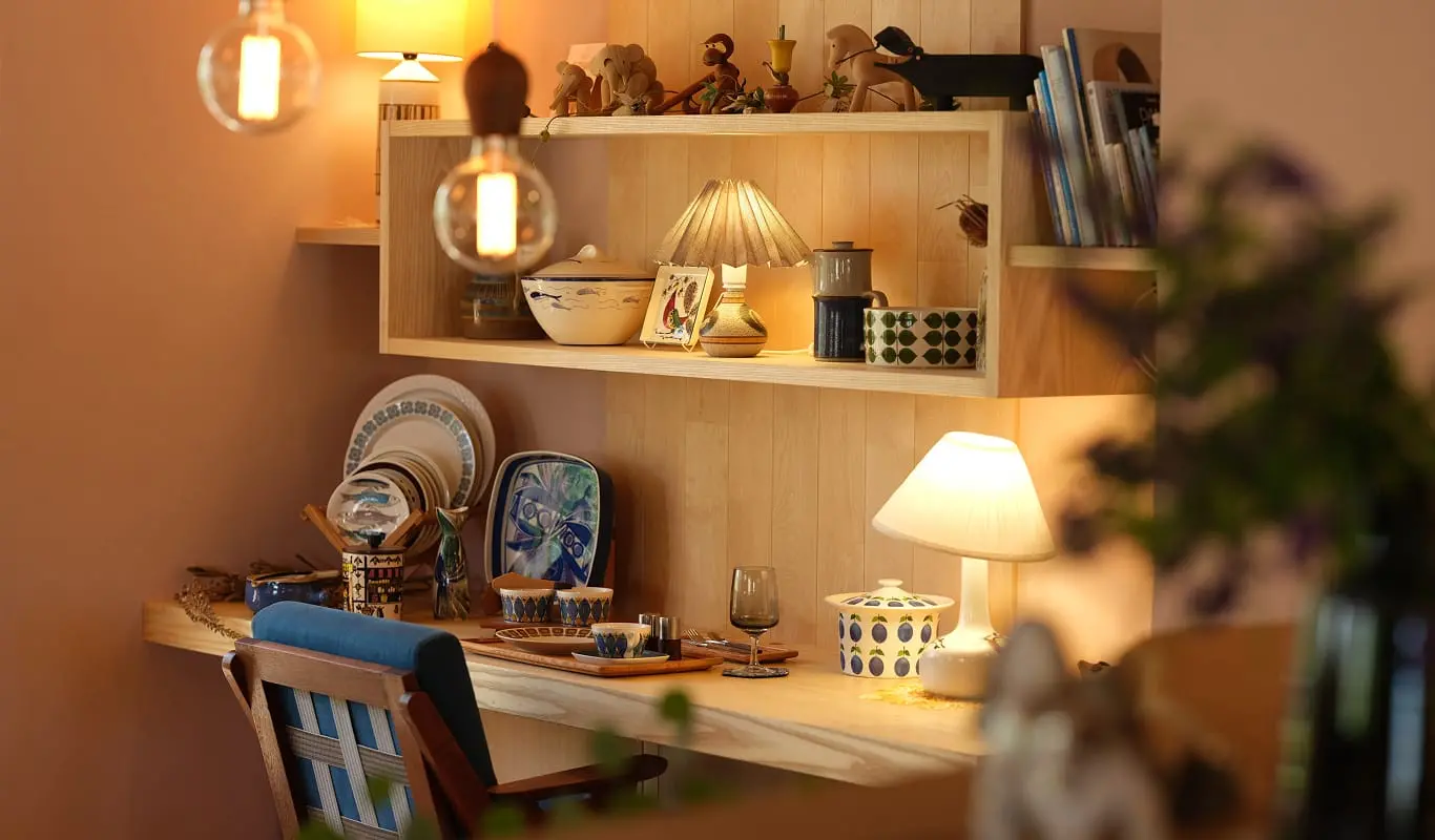 木の温もりが感じられるカフェの一角で、棚や机に器や小物が丁寧に並べられている